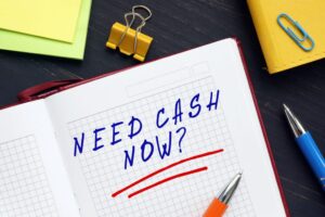 NEED CASH NOW written in notebook of licensed moneylender offering fast cash in Singapore