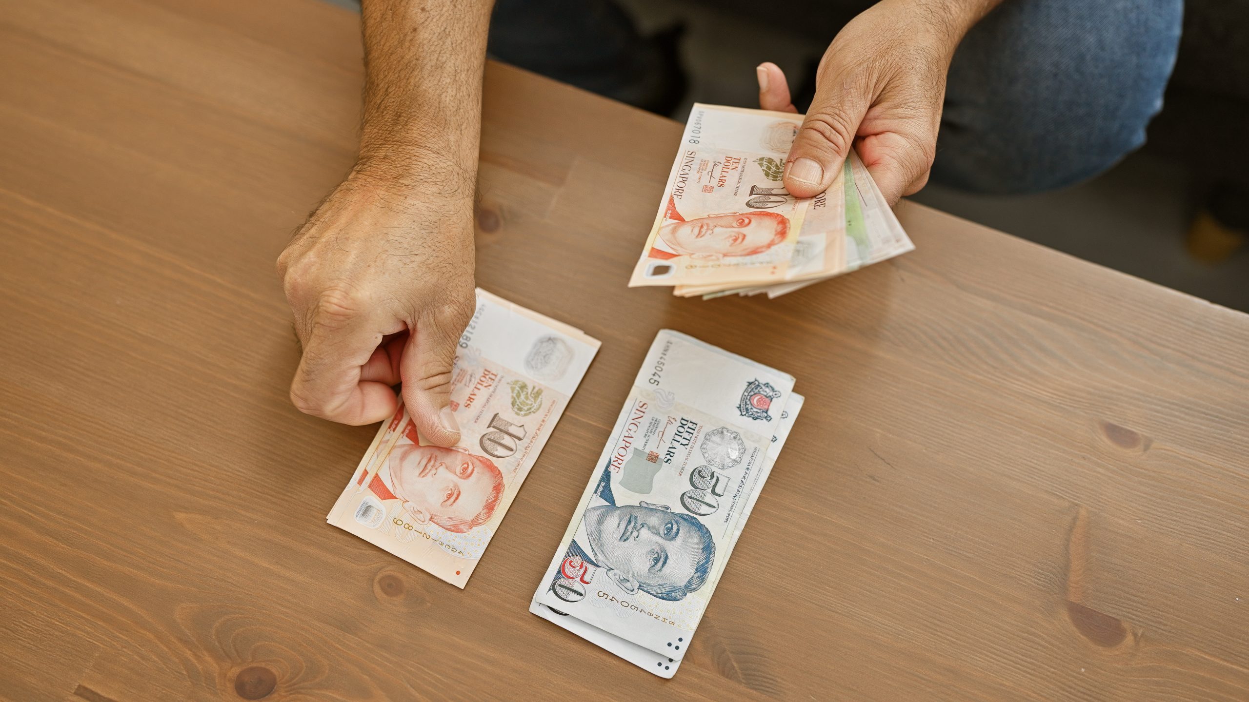 A borrower laying out cash on the table to repay his renovation loan instalment for the month