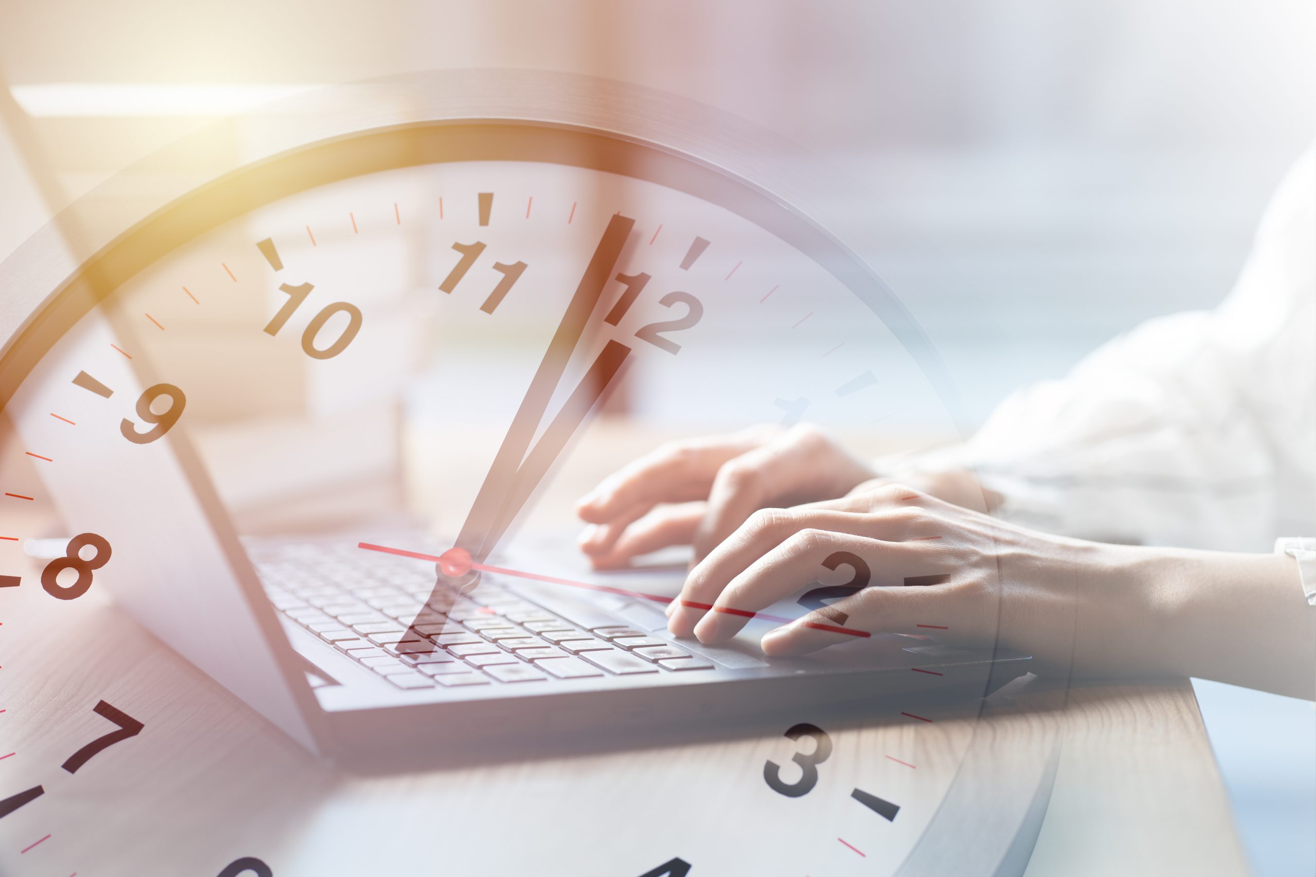 A clock overlaying the laptop, signifying a visual representation of the speediness in applying for a monthly loan