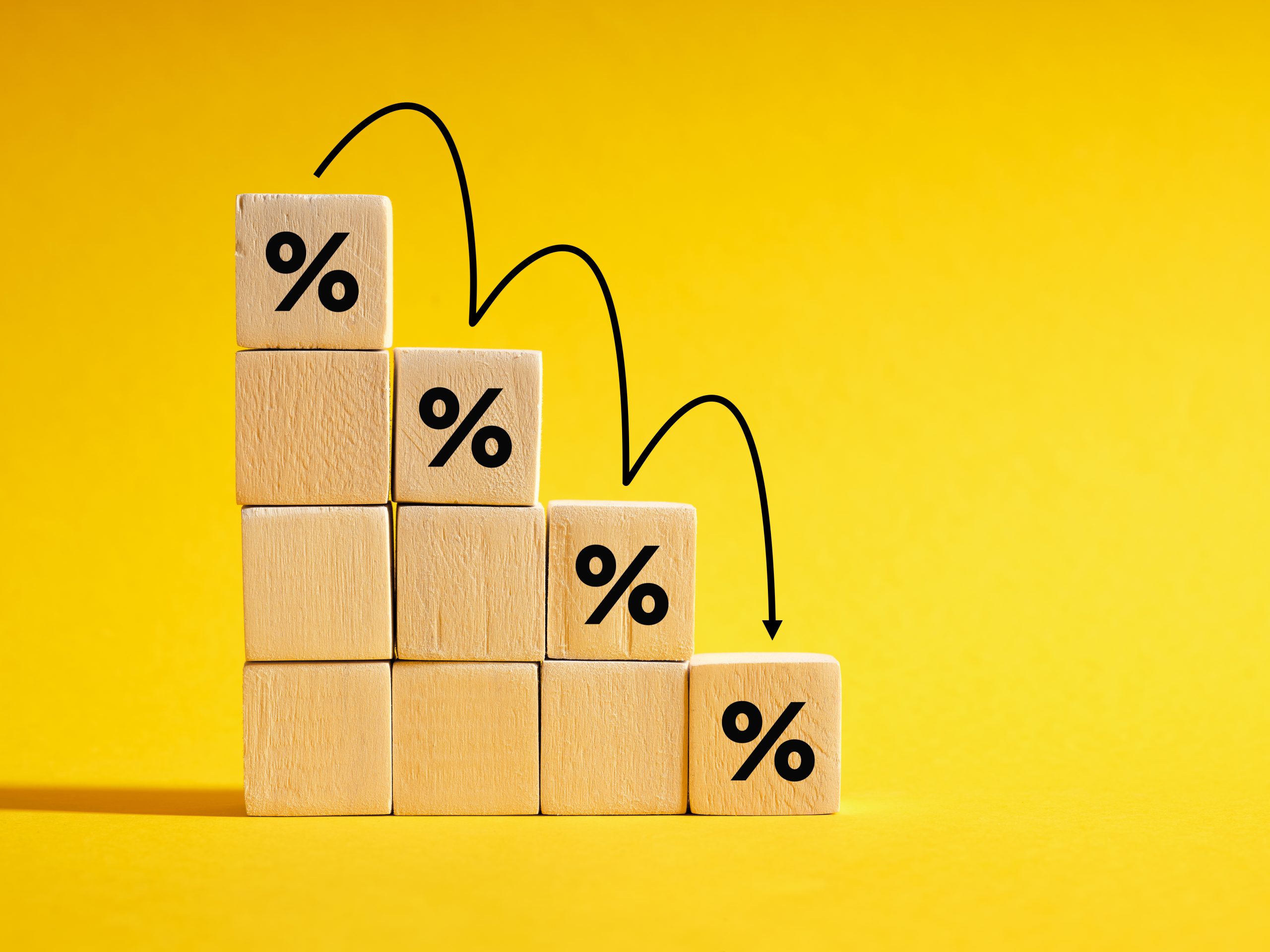 Wooden blocks of percentage signs in descending numbers, signifying the low interest rates of MM Credit's personal loan